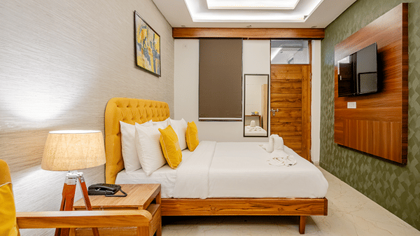 Comfortable hotel room setting with a large bed, bedside lamps, and a wooden feature wall.