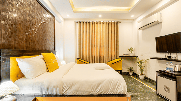 Deluxe hotel room with a king bed, television, and elegant furnishings.