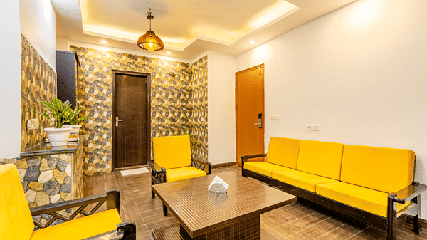 Spacious hotel suite with a sofa seating area and contemporary interiors.