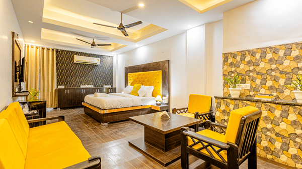 Spacious premium suite with a king bed, sofa seating, and modern interiors.