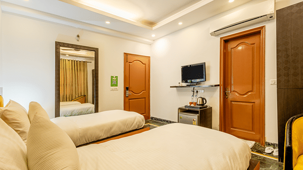 Twin-bed hotel room featuring modern amenities and contemporary décor