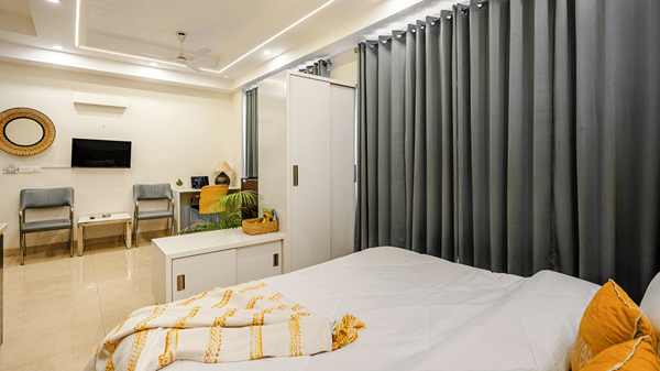 Suite of Lime Tree Luxury Studio featuring grey curtains, a wall mounted television, and seating.