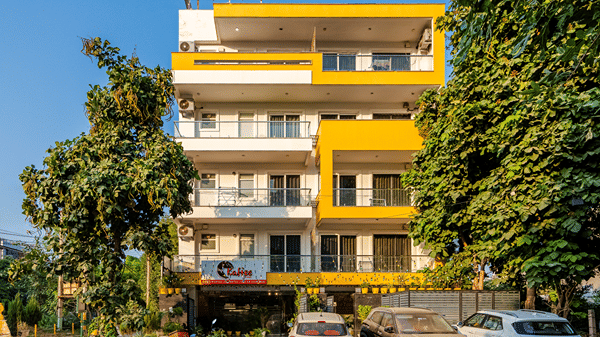 Multiple storey building exterior of Lime Tree Luxury Studio featuring a facade and surrounding trees.
