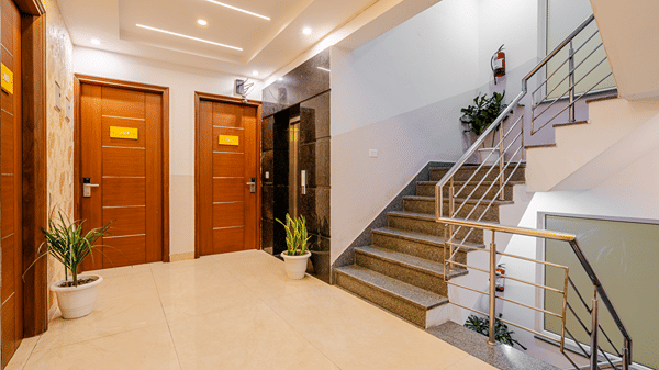 Corridor of Lime Tree Luxury Studio featuring a staircase, wooden doors, and marble flooring.