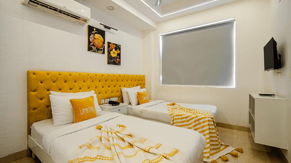 Bedroom of Lime Tree Luxury Studio featuring twin beds, a tufted headboard, and cushions.