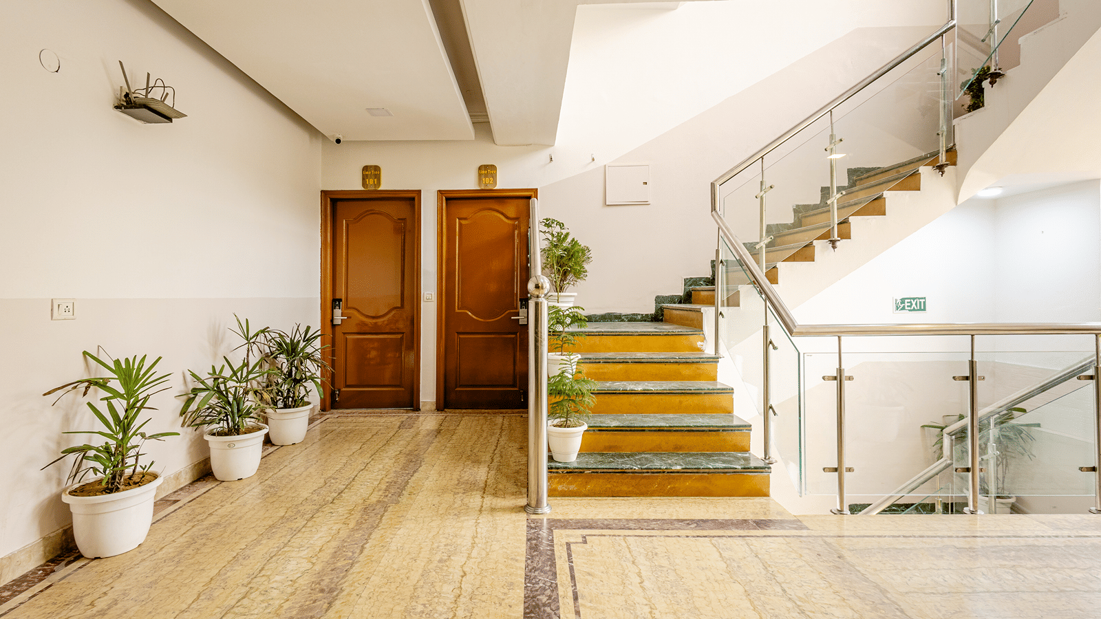 Hotel corridor leading to a staircase with bright and spacious interiors.