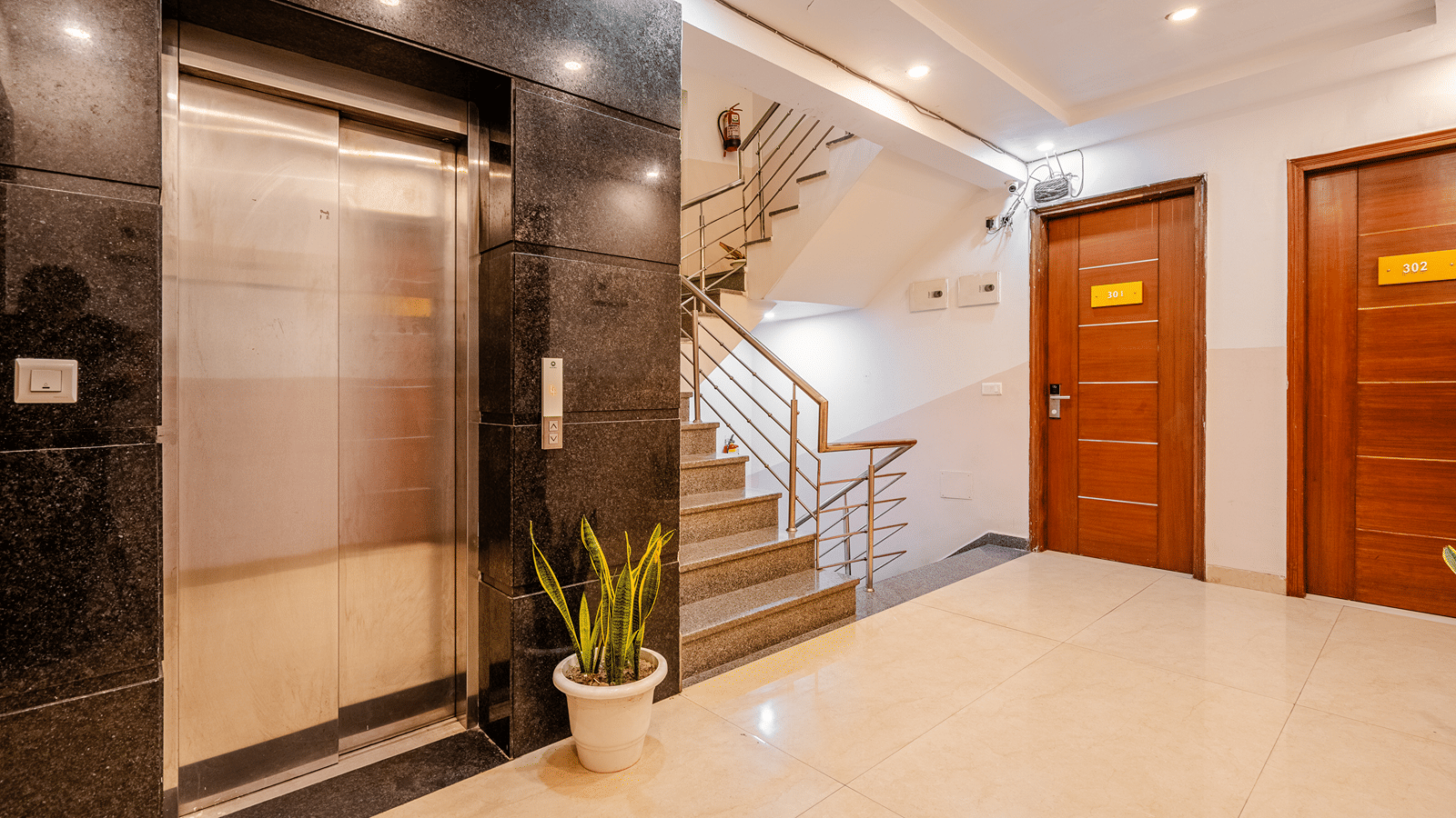Corridor of Lime Tree Luxury Studio featuring a lift, a staircase, and wooden doors.