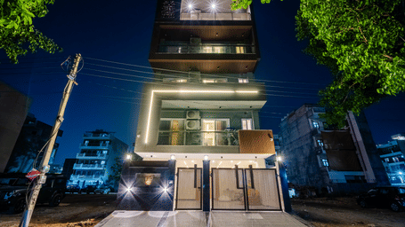 Night view of the multi-storey serviced apartment building with bright lighting at Lime Tree 1BHK Service Apartment Near Artemis Hospital Gurgaon.