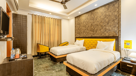 Spacious twin-bedroom with modern furnishings and a seating area.