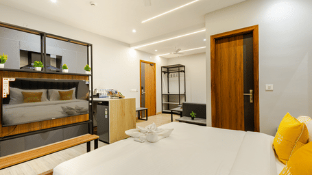 Suite of Lime Tree Hotels & Service Apartment Private Limited featuring a wood panelled wall, a bed, and a wardrobe.