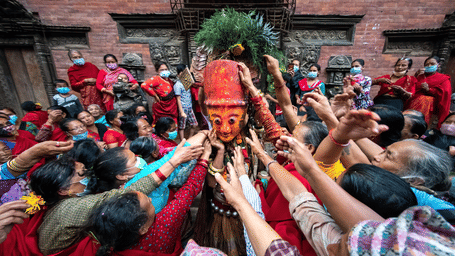 Devotees lifting a traditional deity mask during Indra Jatra festival celebrations at Bhaktapur Durbar Square, a UNESCO site in Nepal.