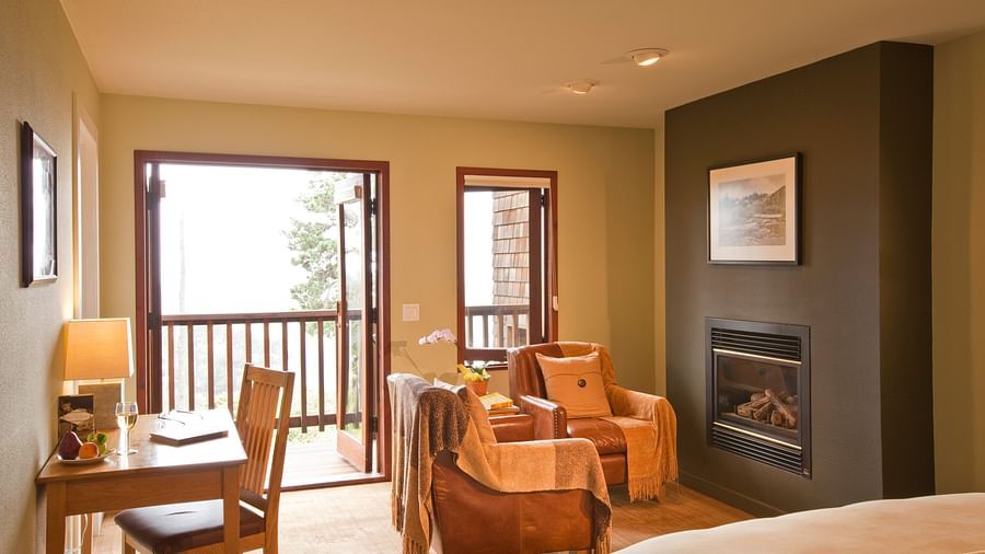 A spacious, elegant hotel room with large windows showcasing beautiful greenery outside, offering a tranquil and inviting atmosphere - Brewery Gulch Inn & Spa