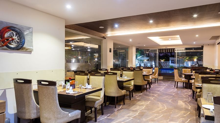 Image of a dining area with tables and chairs and lights in the ceiling at Calux Grand Baga.