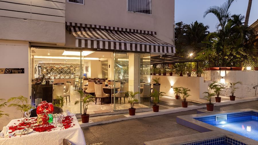 Image of poolside dining area with a table decorated with flowers at Calux Grand Baga.