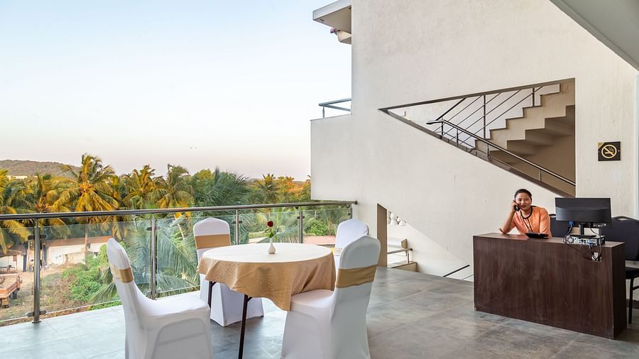 Image of a woman sitting behind a table and a view of the surrounding area on the side at Calux Grand Baga.