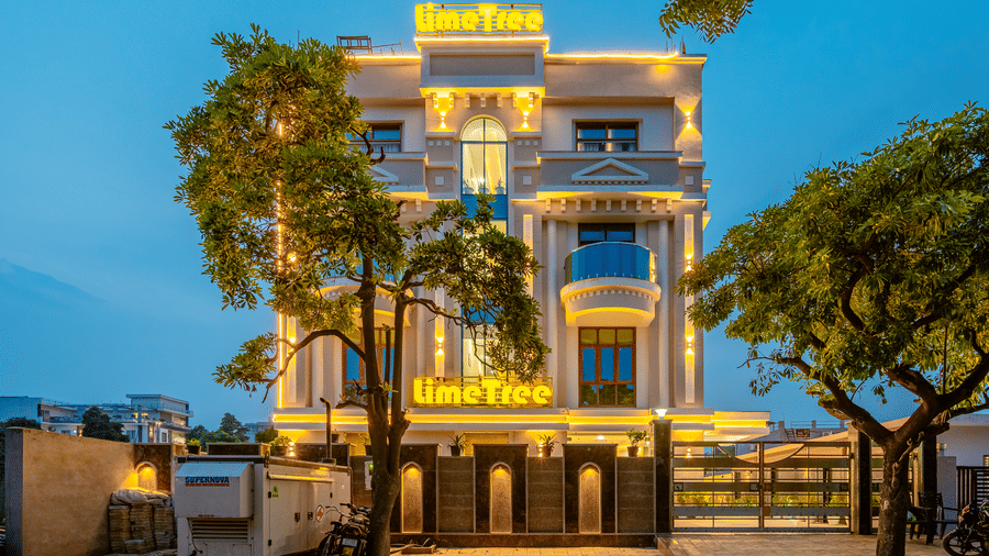 Exterior view of a modern multi-storey hotel building beautifully illuminated at dusk.