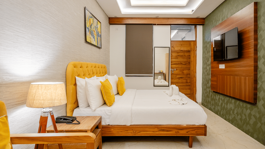 Comfortable hotel room setting with a large bed, bedside lamps, and a wooden feature wall.