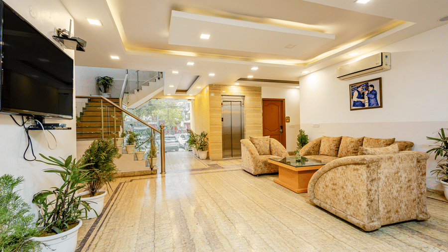 A wide view of the sofas and TV screen in the lobby of Lime Tree Hotels and Banquet Hall Near Huda Metro, Gurgaon