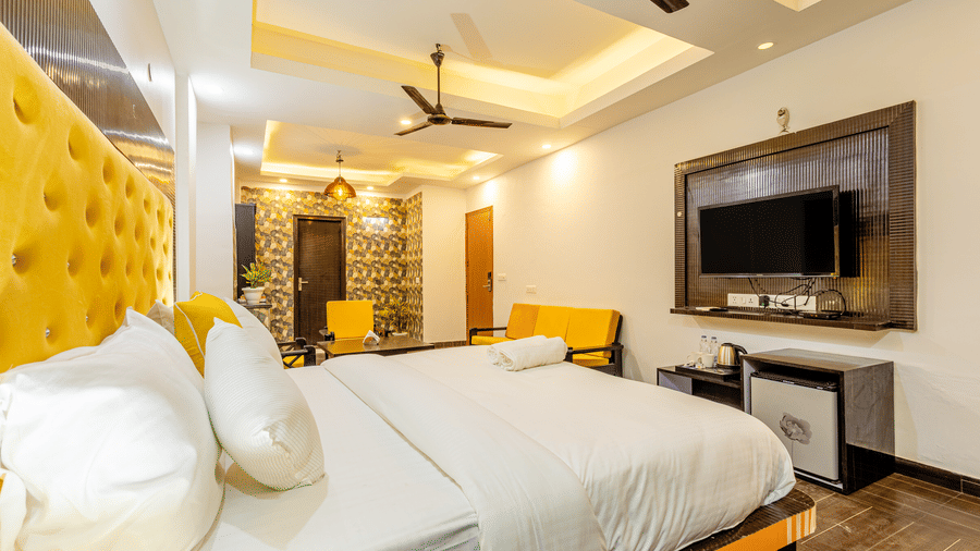 Side view of the king size bed in the suite at Lime Tree Hotels and Banquet Hall Near Huda Metro, Gurgaon