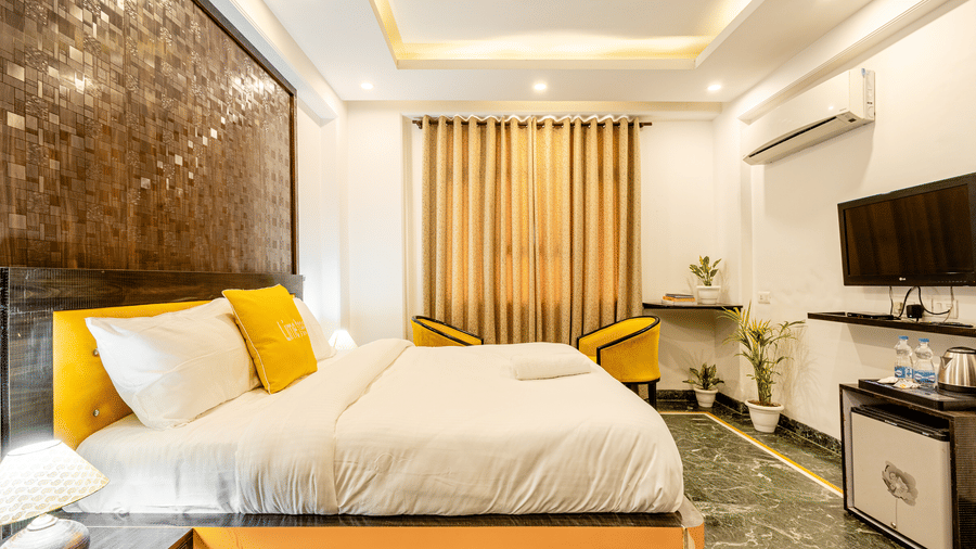 Deluxe hotel room with a king bed, television, and elegant furnishings.
