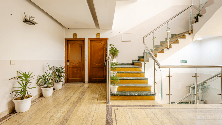 Hotel corridor leading to a staircase with bright and spacious interiors.