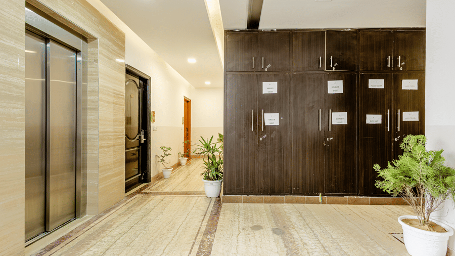 Contemporary lift lobby with elevators and decorative indoor plants.
