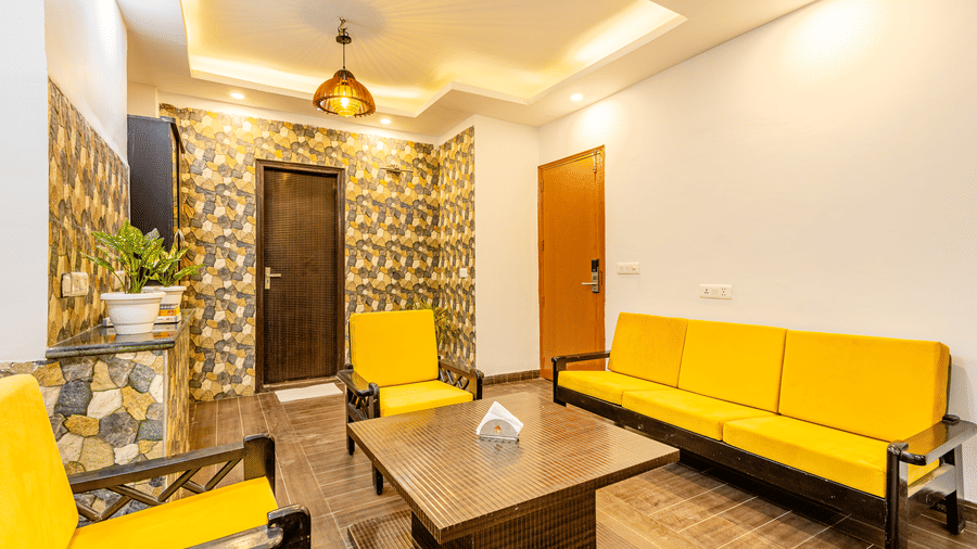 Spacious hotel suite with a sofa seating area and contemporary interiors.
