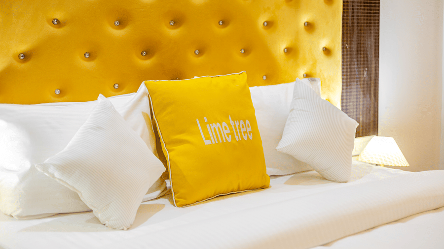 Close-up of a king-size bed with plush pillows and a tufted headboard.