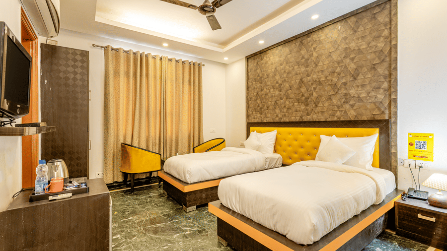 Spacious twin-bedroom with modern furnishings and a seating area.