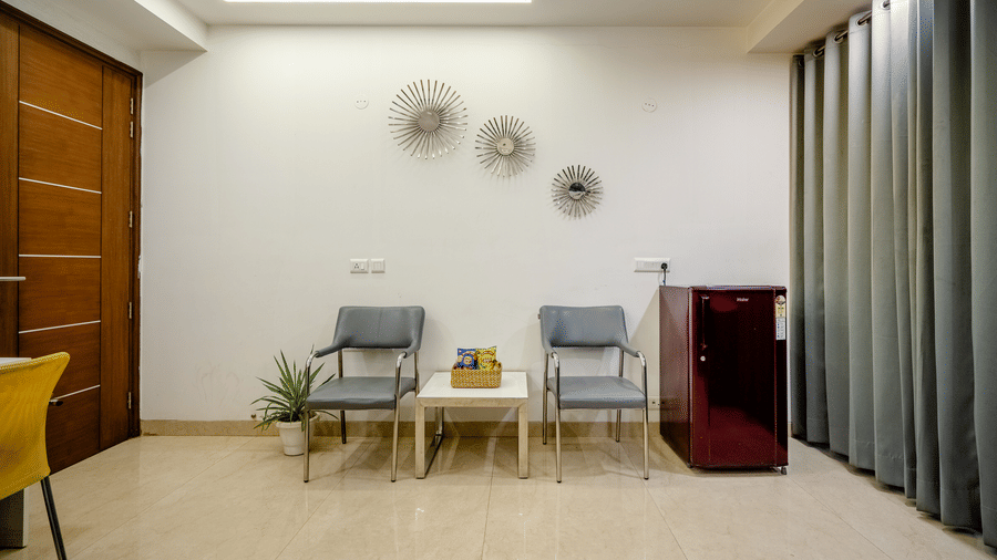 Lounge area of Lime Tree Luxury Studio featuring armchairs and dark curtains.