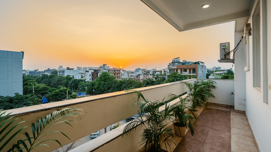Balcony of Lime Tree Luxury Studio featuring potted plants and a sunset view of the surroundings.
