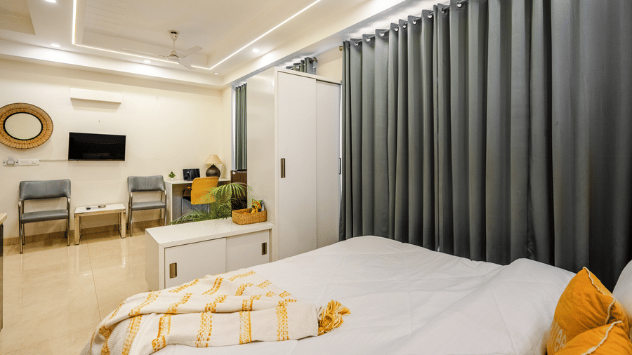 Suite of Lime Tree Luxury Studio featuring grey curtains, a wall mounted television, and seating.