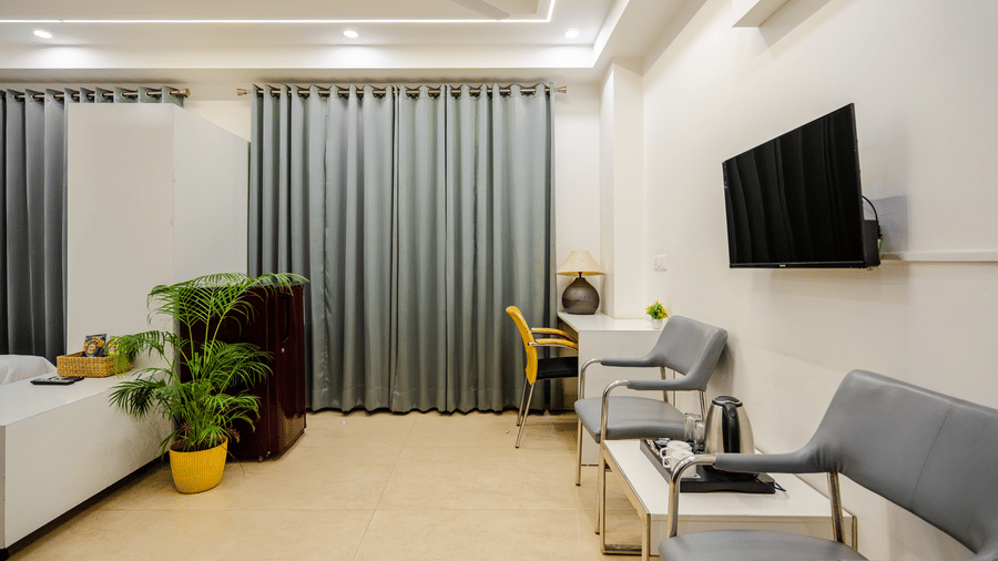 Bedroom of Lime Tree Luxury Studio featuring grey curtains, a work desk, and a chair.
