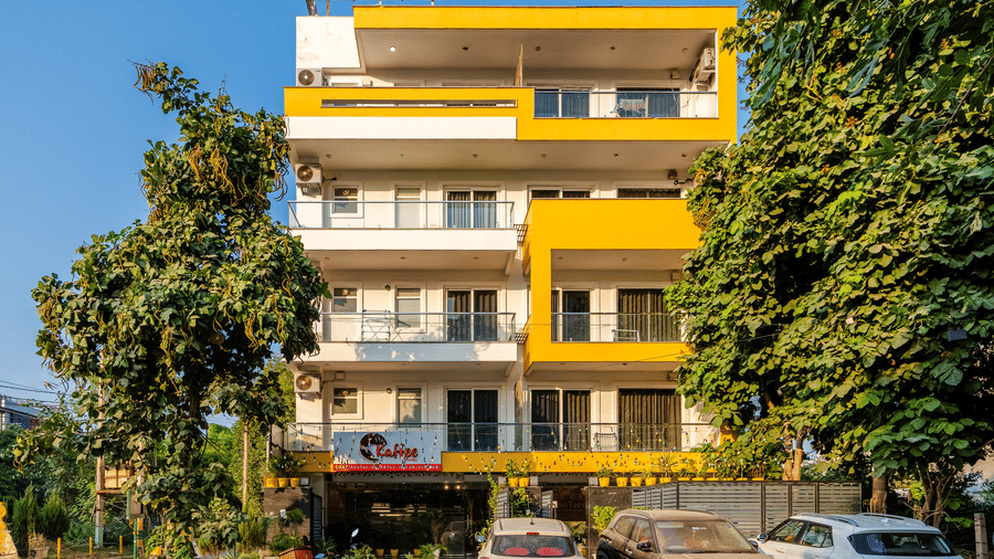 Multiple storey building exterior of Lime Tree Luxury Studio featuring a facade and surrounding trees.