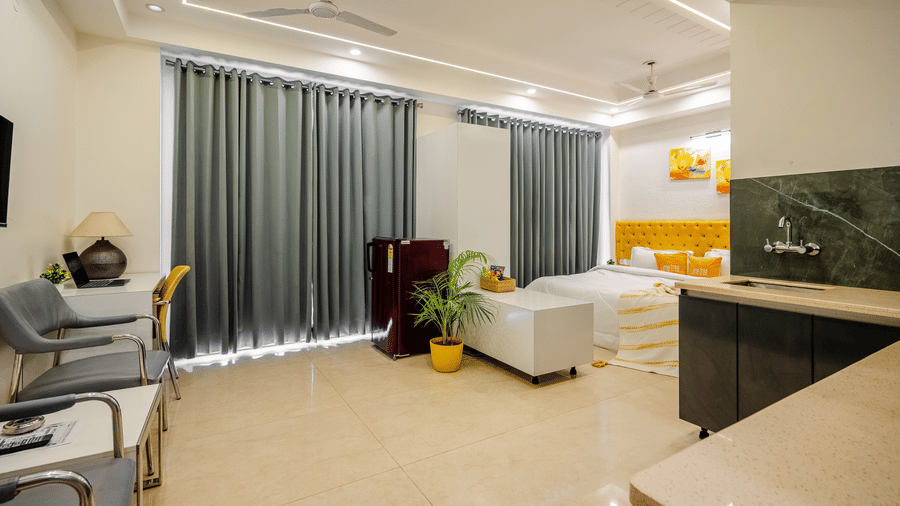 Suite of Lime Tree Luxury Studio featuring an open kitchen, seating, and grey curtains.
