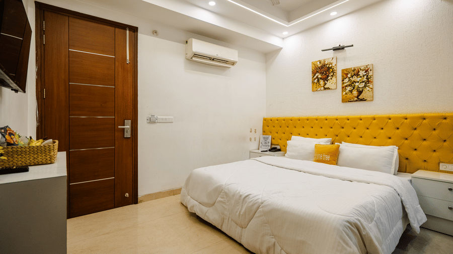 Bedroom of Lime Tree Luxury Studio featuring a headboard, bedding, and a wooden door.