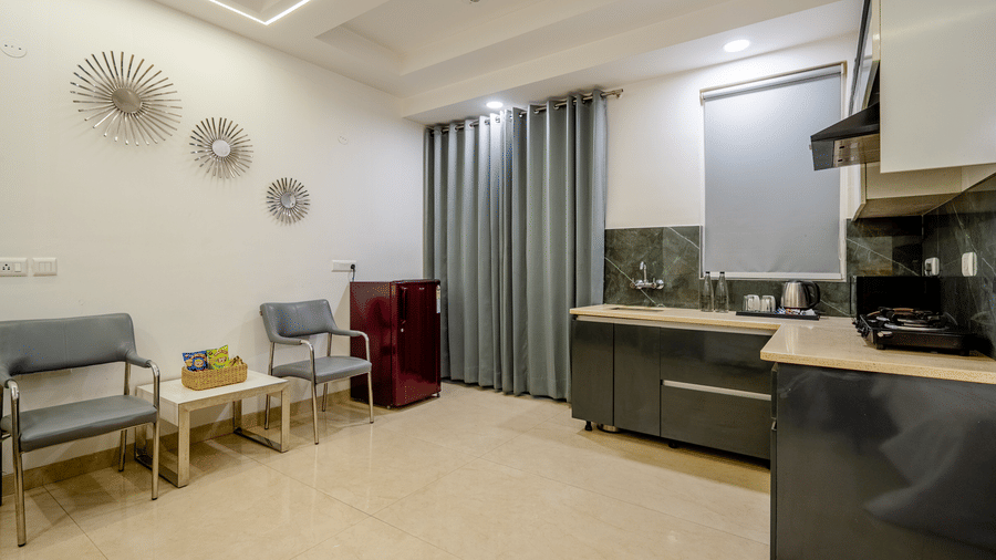 Suite of Lime Tree Luxury Studio featuring an open kitchen, seating, and grey curtains.