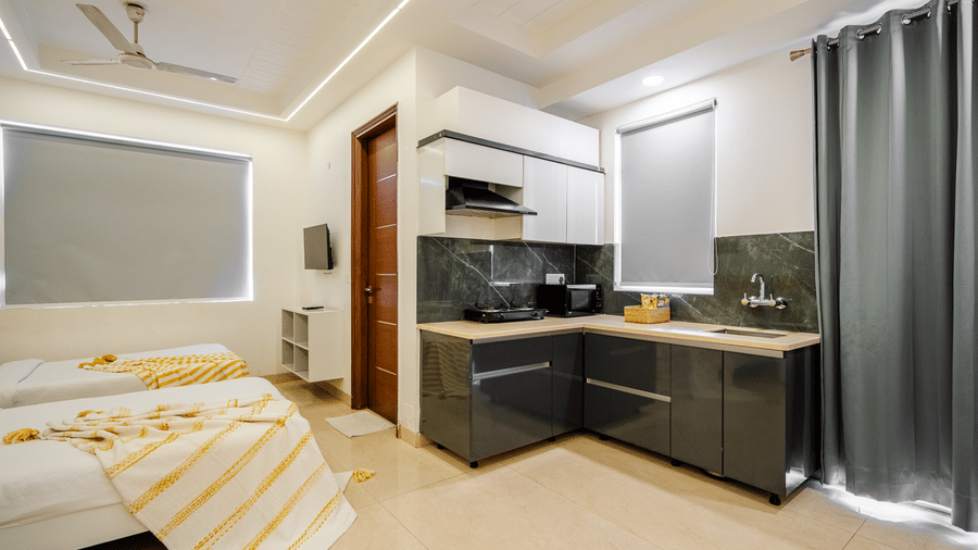 Suite of Lime Tree Luxury Studio featuring an open kitchen, a striped bedspread, and grey curtains.
