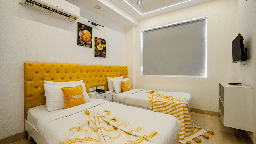 Bedroom of Lime Tree Luxury Studio featuring twin beds, a tufted headboard, and cushions.