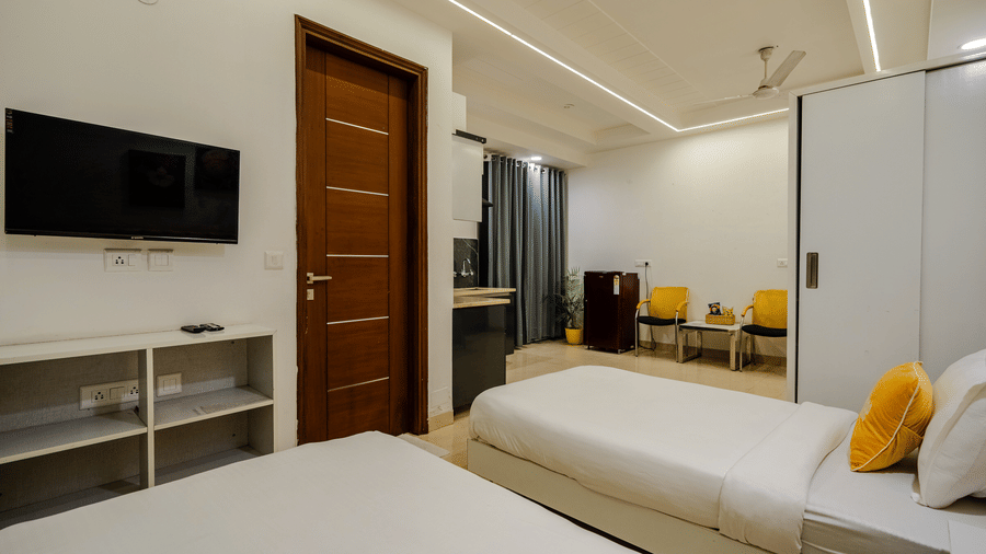 Bedroom of Lime Tree Luxury Studio featuring a wardrobe, twin beds, and cushions.