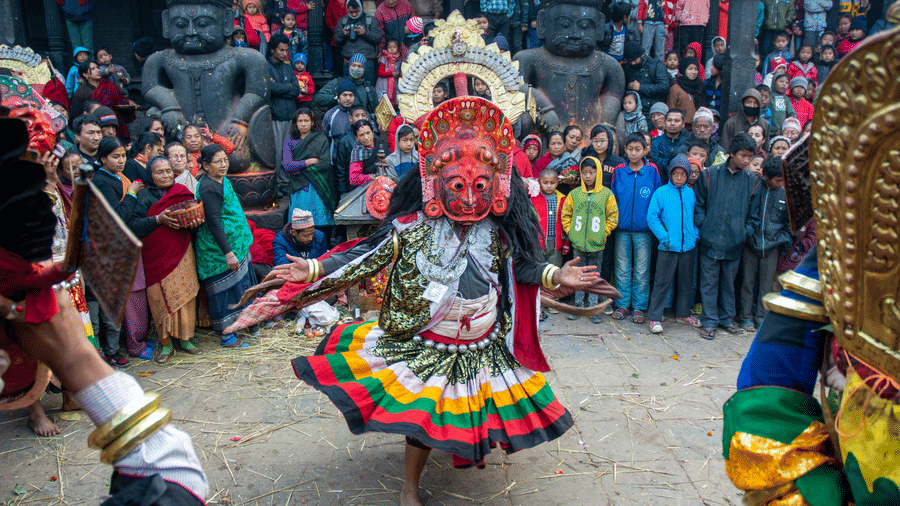 A traditional Newari performer performs the sacred Nava Durga masked dance in a public square in the historic city of Bhaktapur, Nepal.