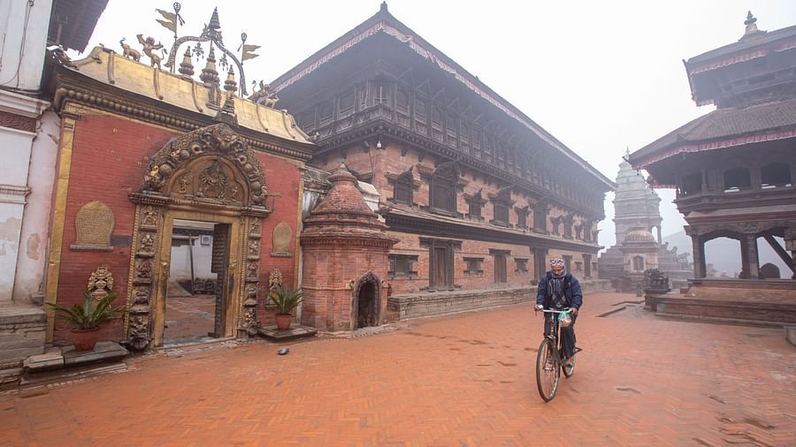 A facade view of the 55 window palace with golden gate in front of which a man is riding his bicycle