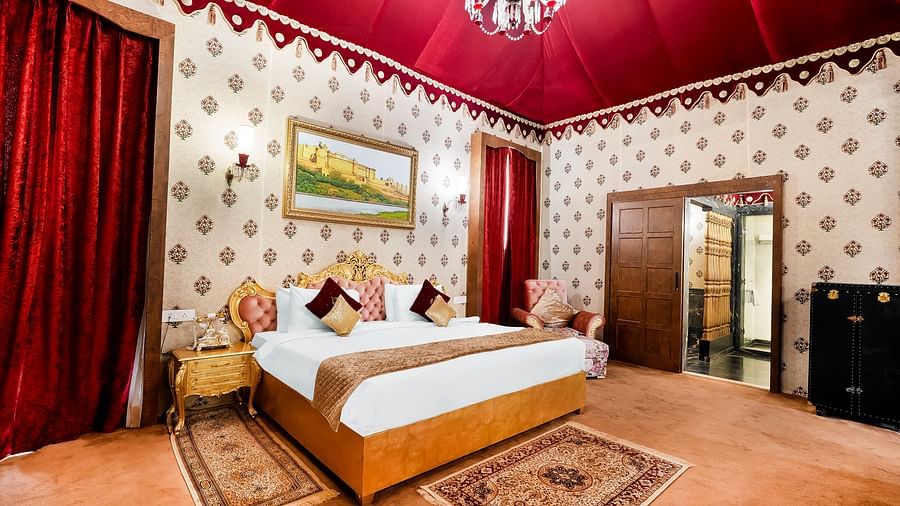 An overview of a room with a double bed, side table and a chandelier - Rajasthali Resort & Spa, Jaipur.