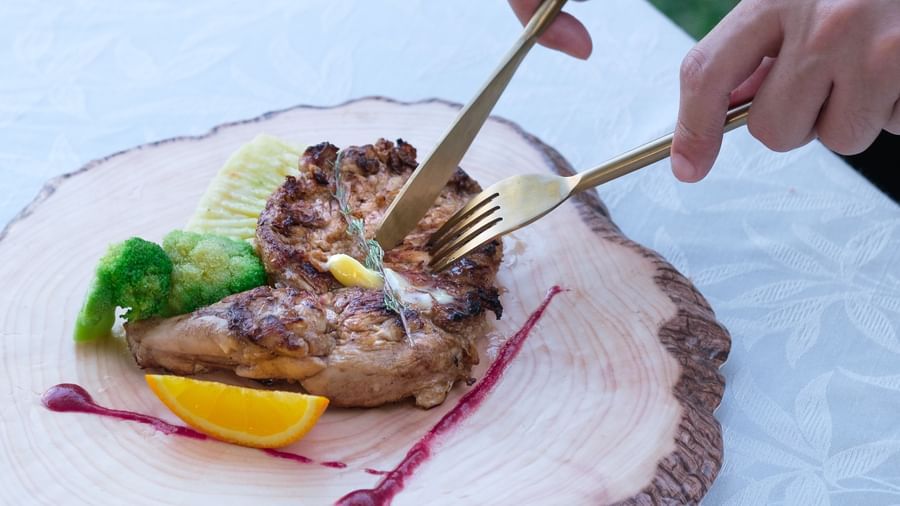 A person digging into Grilled Chicken | Mango Hill, Pondicherry