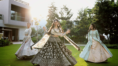 A bride and two women posing for a picture in front of a villa - Karma Lakelands.