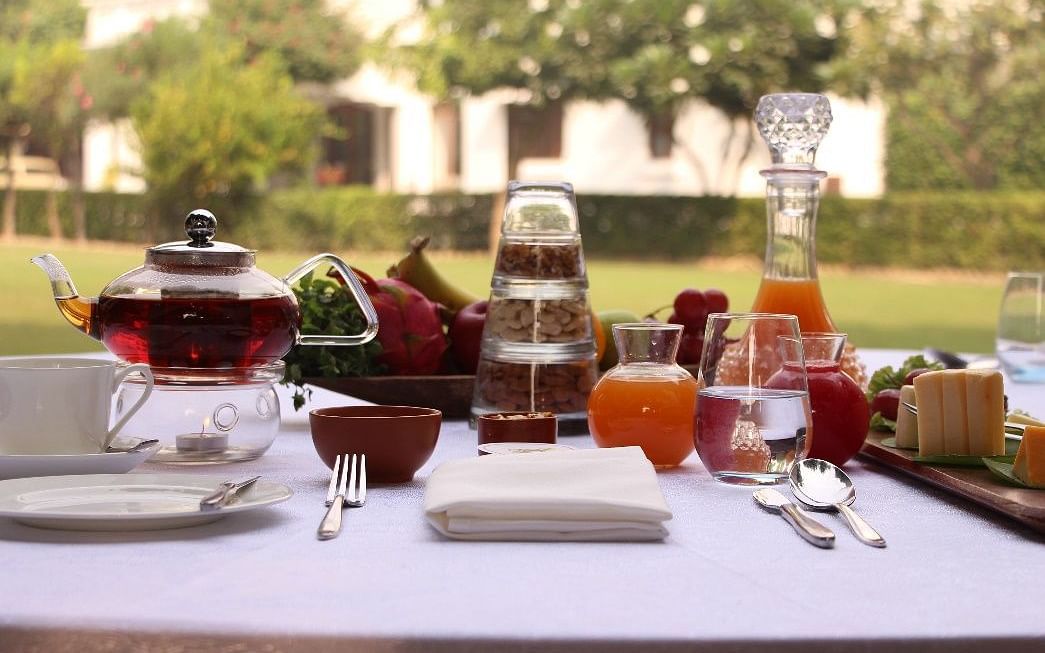 A breakfast arrangement with a variety of teas placed on an outdoor table with the garden in the backdrop