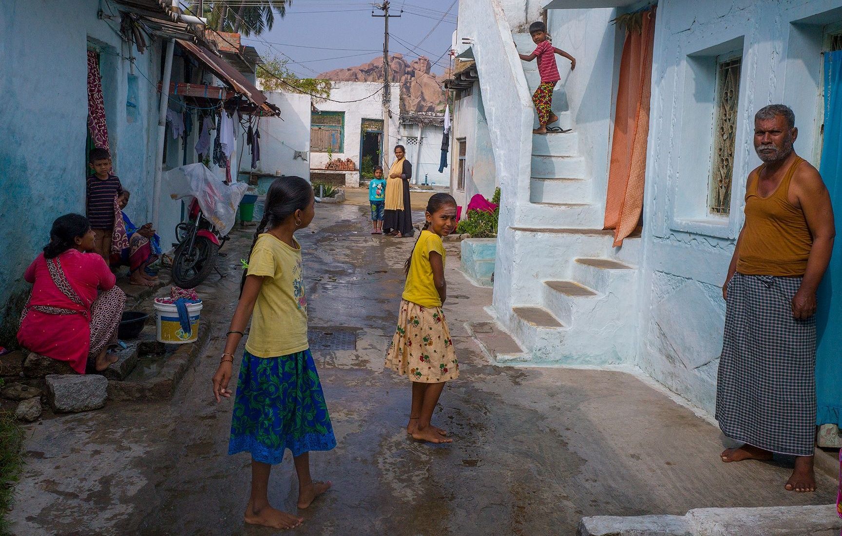 Village street scene in Hampi with blue houses.