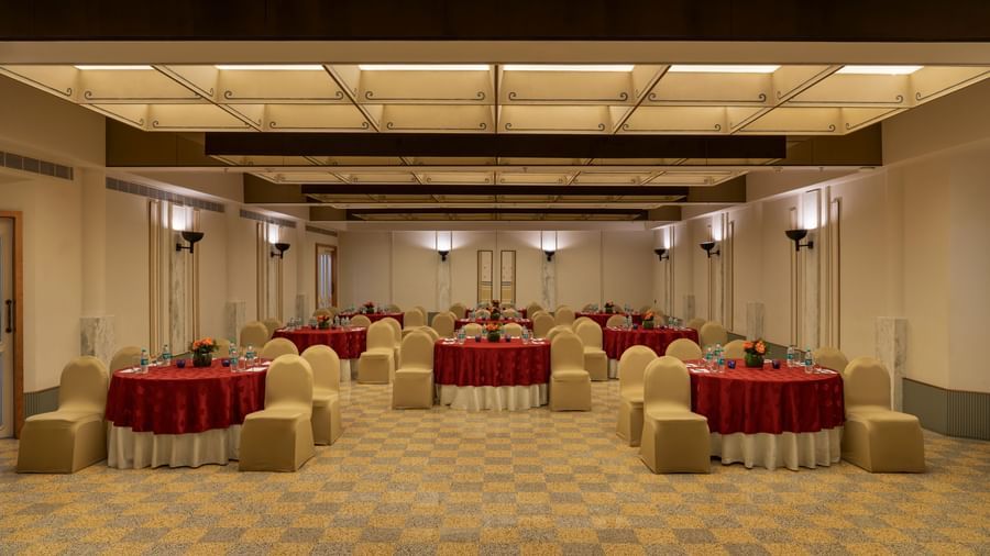  A banquet hall at Shilton International, Kochi, set with round tables and chairs for a gathering.