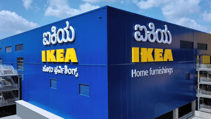 A bright facade of IKEA Bengaluru, featuring a bright blue exterior colour with the brand name written in English and Kannada language.