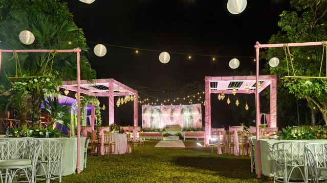 Event space with paper lanterns and fairy lights at night.